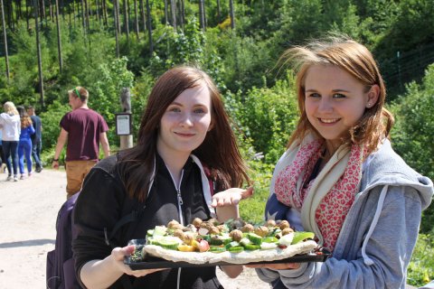 Teilnehmerinnen des Ferienprogramms präsentieren eine Bärentorte, die sie selbst zubereitet haben und anschließend an die Tiere verfüttern.  Foto: STIFTUNG für BÄREN